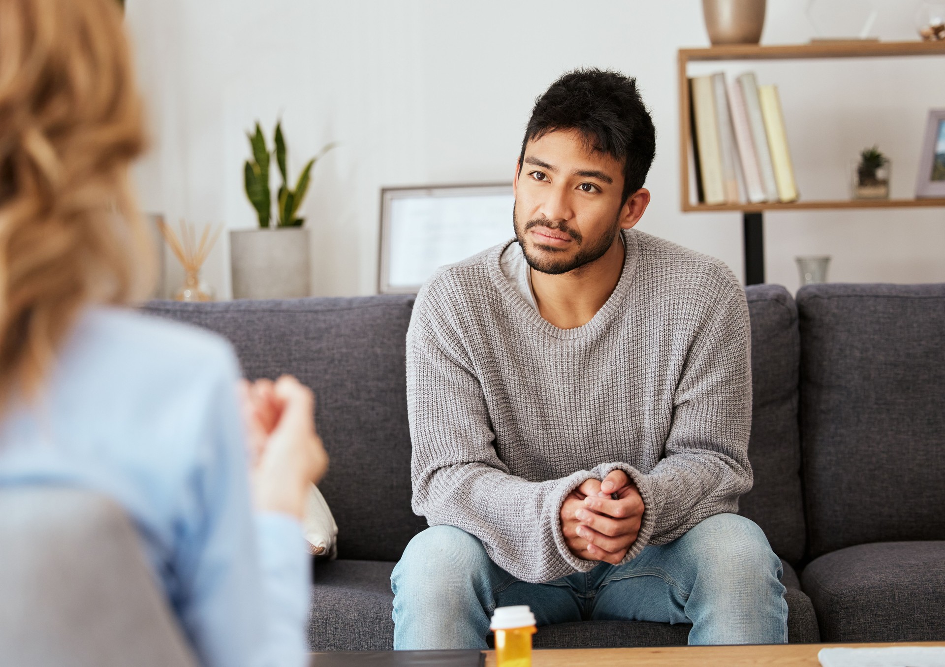 Shot of a young man having a therapeutic session with a psychologist